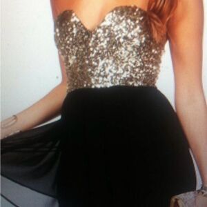 Parvenue mini dress Black & Gold and zips up in the back. FromNWT Size M